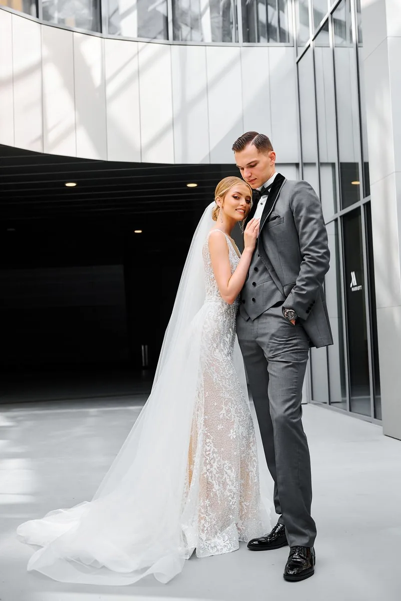 Couple cutting elegant white wedding cake at sunset