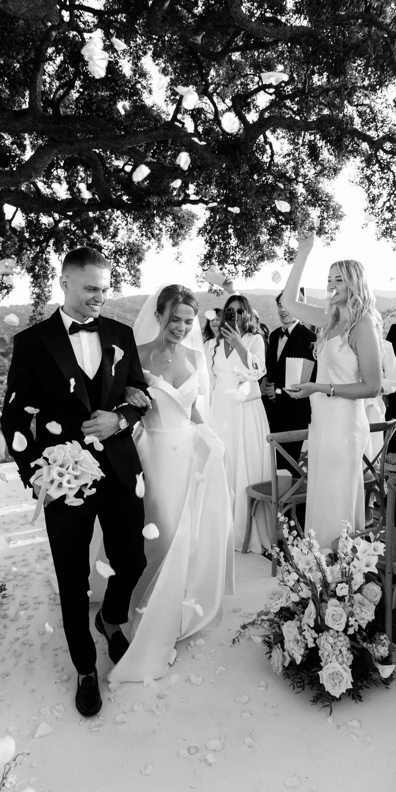 Black and white bride ascending grand palace staircase with floral arch