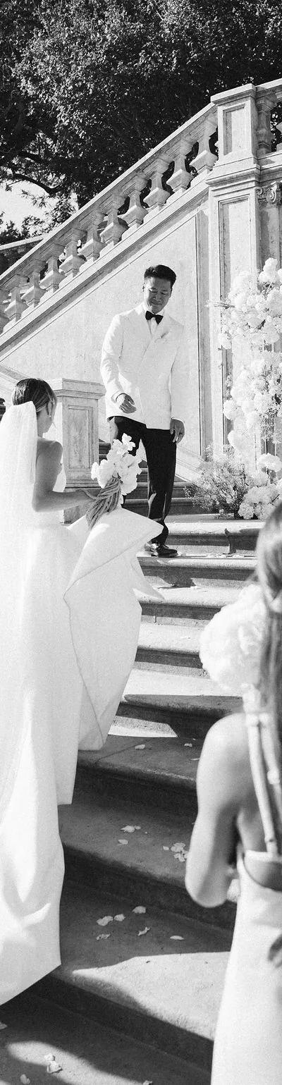 Couple portrait at a balcony under a vintage lantern, groom in black tie