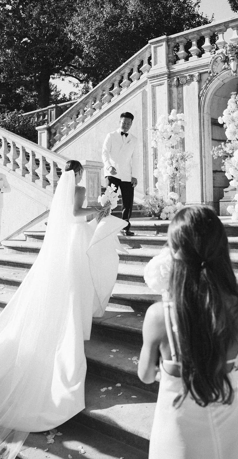 Couple portrait at a balcony under a vintage lantern, groom in black tie