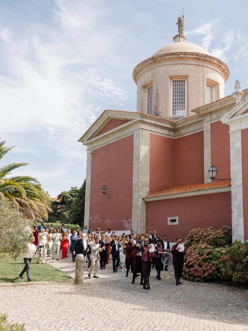Wedding procession past a red domed palace in Portugal