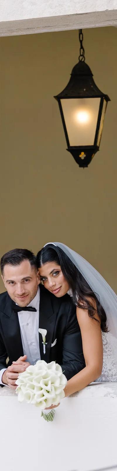 Black and white couple walking down ceremony aisle with petals under old tree