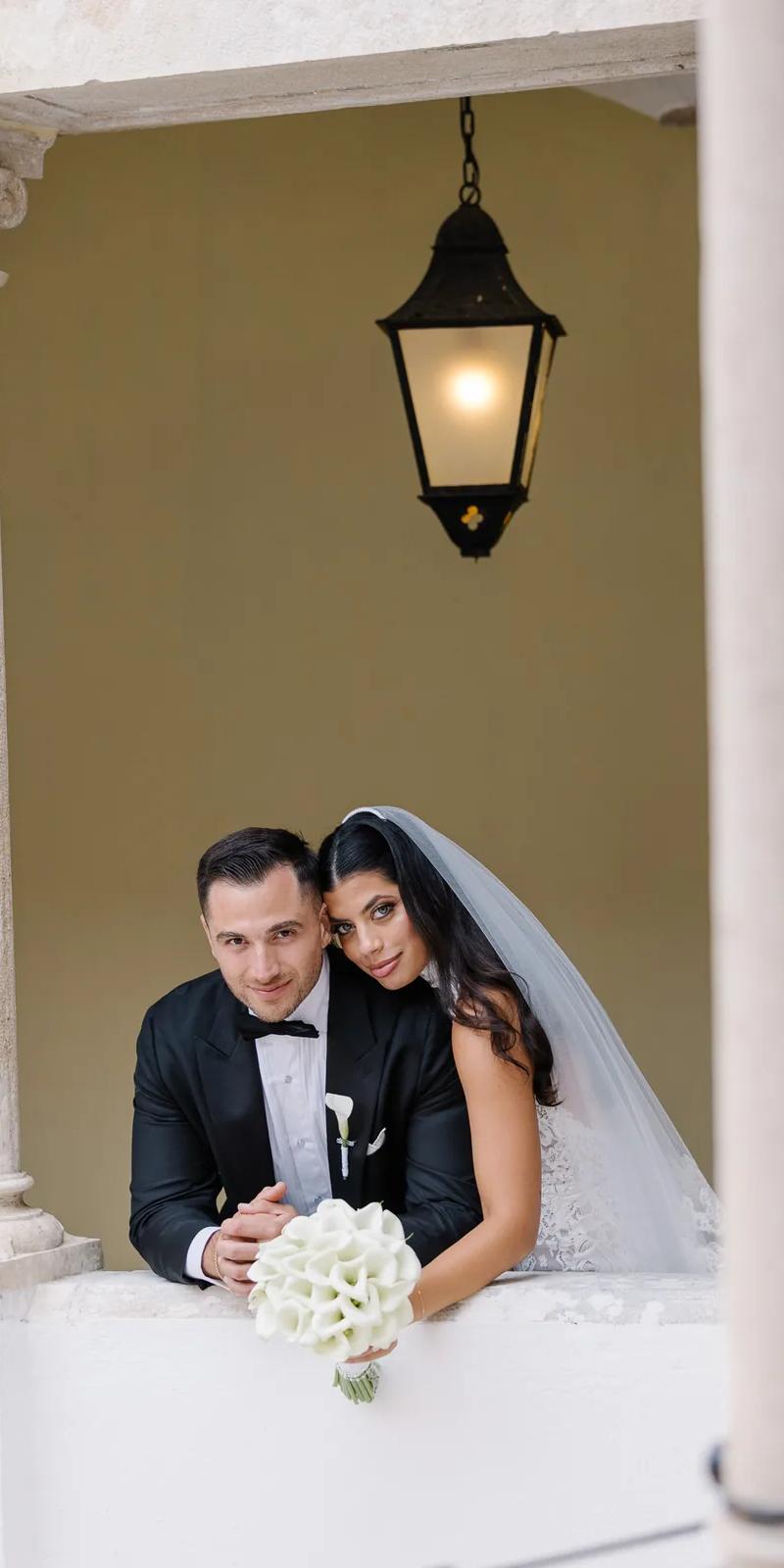 Black and white couple walking down ceremony aisle with petals under old tree